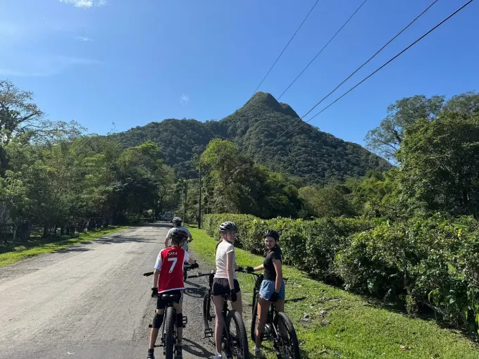 Un grupo recorriendo El Valle de Antón en bicis eléctricas E-Valley, con el pico al fondo
